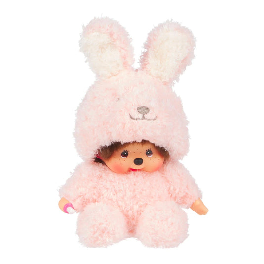 Peluche Monchhichi de Sekiguchi vêtue d'un pyjama combinaison tout doux rose à capuche oreilles de lapin.