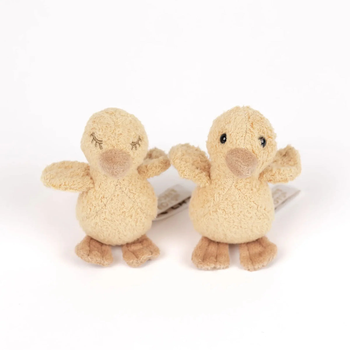 Duo de canetons en peluche Quack Egmont Toys, l'un aux yeux ouverts et l'autre aux yeux brodés fermés.