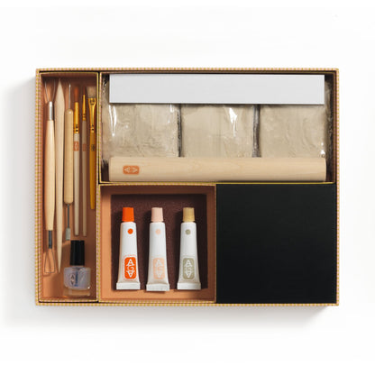 Contenu complet du coffret Atelier Modelage Djeco incluant argile sans cuisson, rouleau en bois, outils de sculpture, pinceaux et peintures.