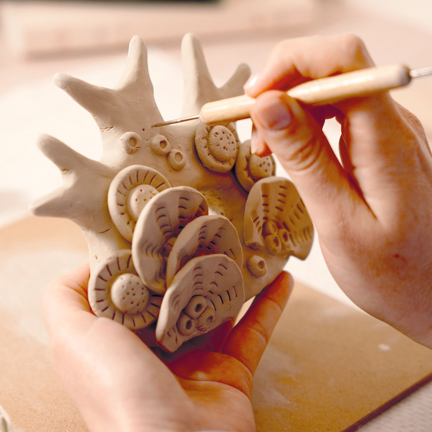 Assemblage minutieux des coquillages et coraux en argile pour former la sculpture tridimensionnelle.