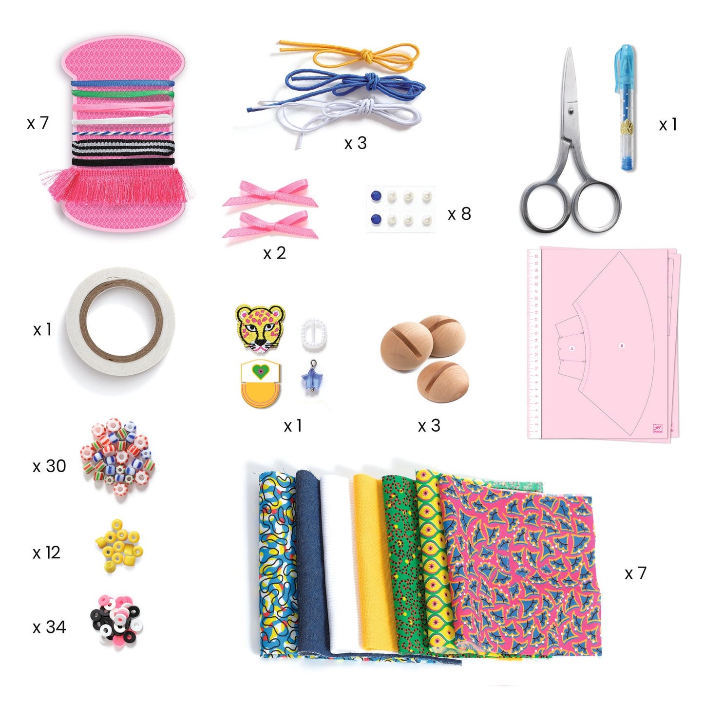 Contenu détaillé du coffret de stylisme avec les pièces de tissus, rubans, perles, ciseaux, patrons et socles en bois.