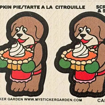 Gros plan sur les autocollants odorants "Grattez et sentez" représentant des chiens marron portant un tablier et tenant une tarte à la citrouille garnie de crème.