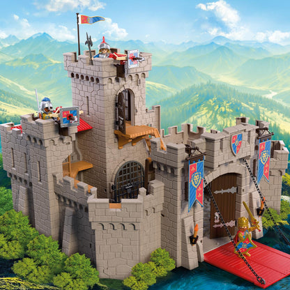 Grand château fort des chevaliers Playmobil Knights avec pont-levis abissé, tours de guet, balistes et figurines de chevaliers en armure.