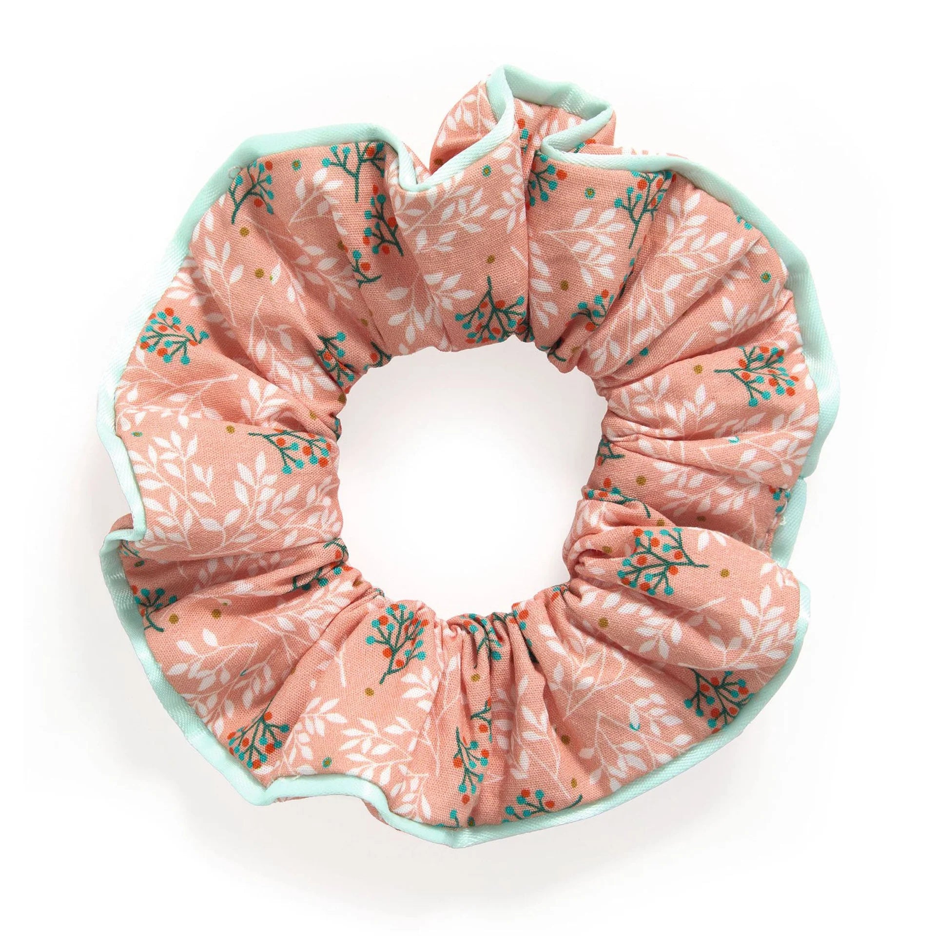 Chouchou à cheveux en tissu rose pêche imprimé de petites feuilles blanches et brindilles à baies, bordé d'un liseré vert menthe, issu de la gamme d'accessoires de coiffure Plume par Djeco.