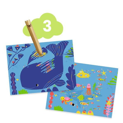 Étape 3 de carte à gratter à l'aide d'un stylet en bois pour révéler une scène sous-marine avec une baleine.