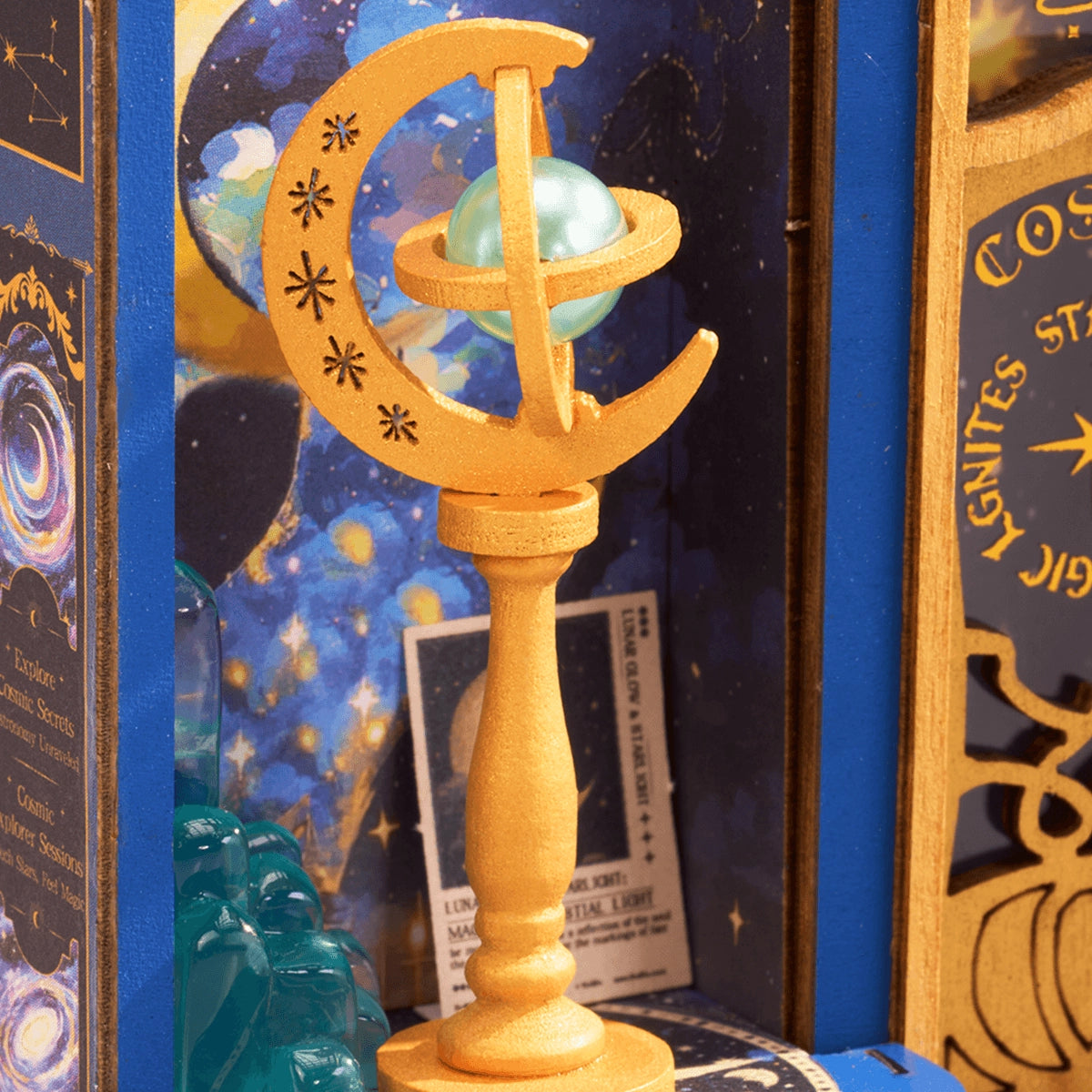 Gros plan sur un détail doré en forme de lune et de globe céleste à l'intérieur de la boutique miniature d'astronomie Rolife.
