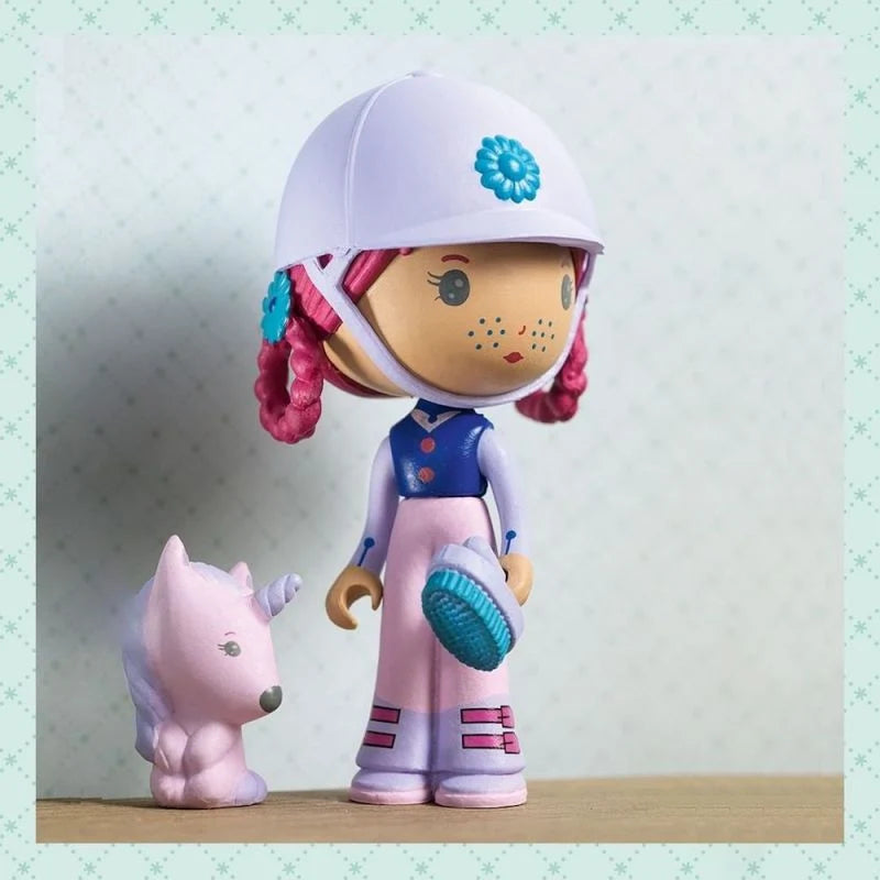 Figurine Joe la cavalière en tenue d'équitation avec casque mauve, brosse bleue et sa petite licorne rose Gala, issue de la collection Tinyly par Djeco.