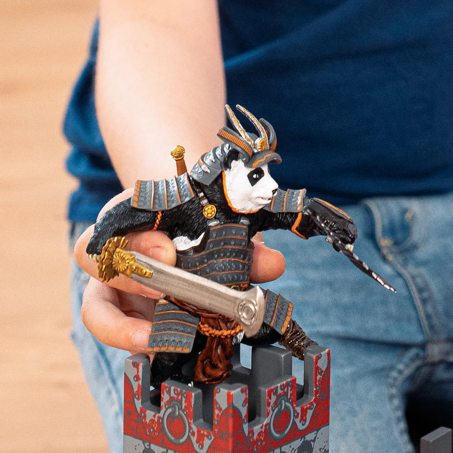 Enfant manipulant la figurine du Mutant panda samouraï Papo sur une tour de château fort.