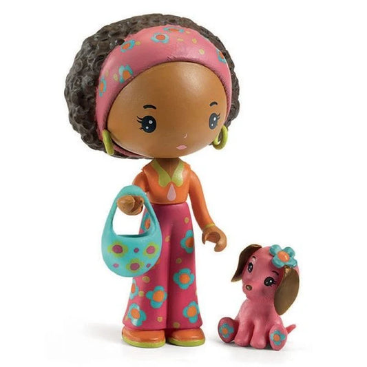 Figurine Poppy au style hippie chic des années 70 avec son bandeau rose floral, son sac turquoise et son petit chien rose Nouky, issue de la collection Tinyly par Djeco.