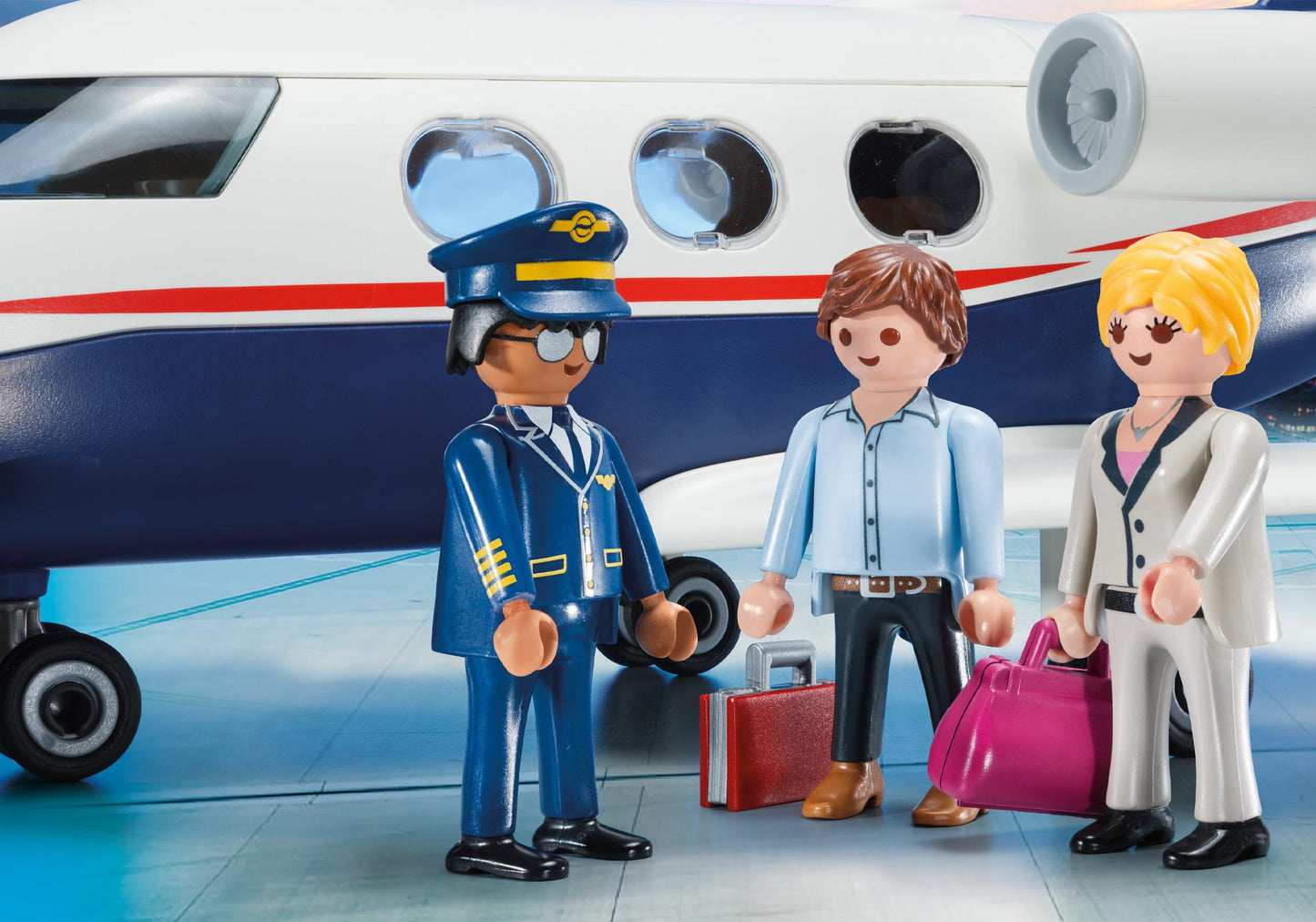 Pilot et passagers Playmobil devant le jet privé avec leurs valises et sacs de voyage.