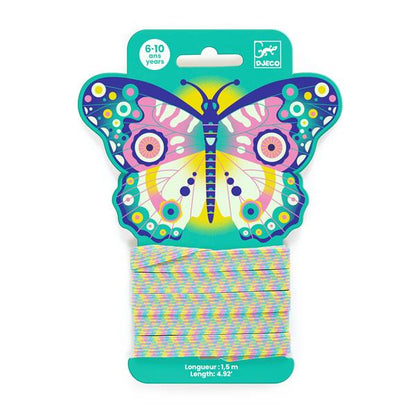 Jeu d'élastique à sauter de 1,5 mètre Djeco, présenté sur un emballage cartonné en forme de grand papillon coloré pour les enfants de 6 à 10 ans.