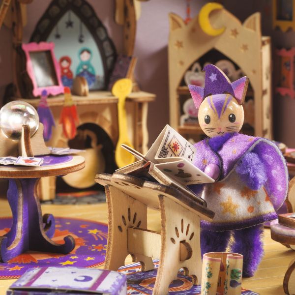 Gros plan sur le personnage chat sorcier lisant un grimoire dans le kit créatif Mi House Astra Djeco, entouré de boules de cristal et meubles magiques.