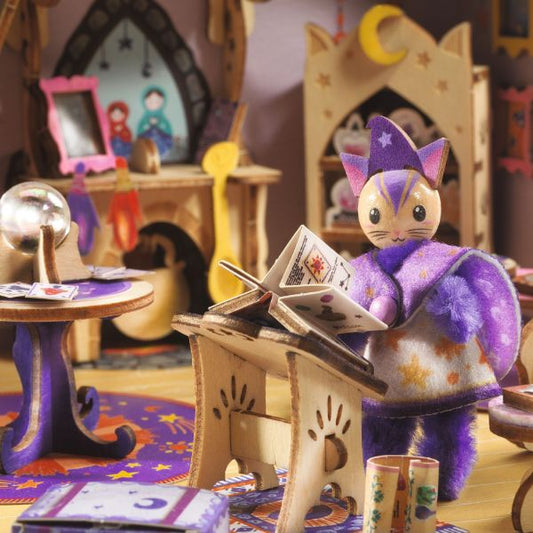 Gros plan sur le personnage chat sorcier lisant un grimoire dans le kit créatif Mi House Astra Djeco, entouré de boules de cristal et meubles magiques.