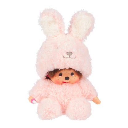 Peluche Monchhichi de Sekiguchi vêtue d'un pyjama combinaison tout doux rose à capuche oreilles de lapin.