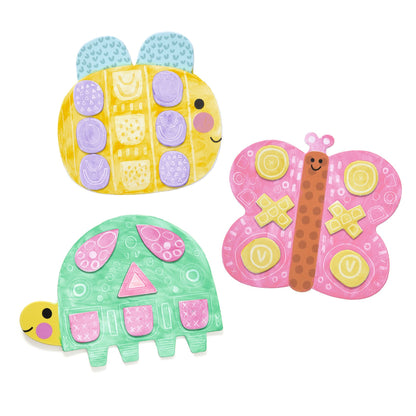 Trois animaux en carton peints et décorés de formes géométriques : une abeille jaune, une tortue verte et un papillon rose.