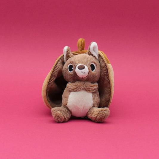 Peluche 2 en 1 Flipetz Les Déglingos représentant un écureuil brun sortant d'un gland en tissu sur fond rose.