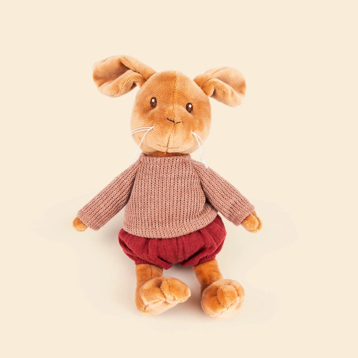 Peluche Lenny le lapin de Egmont Toys, assis, portant un pull en tricot vieux rose et une culotte bouffante rouge brique.
