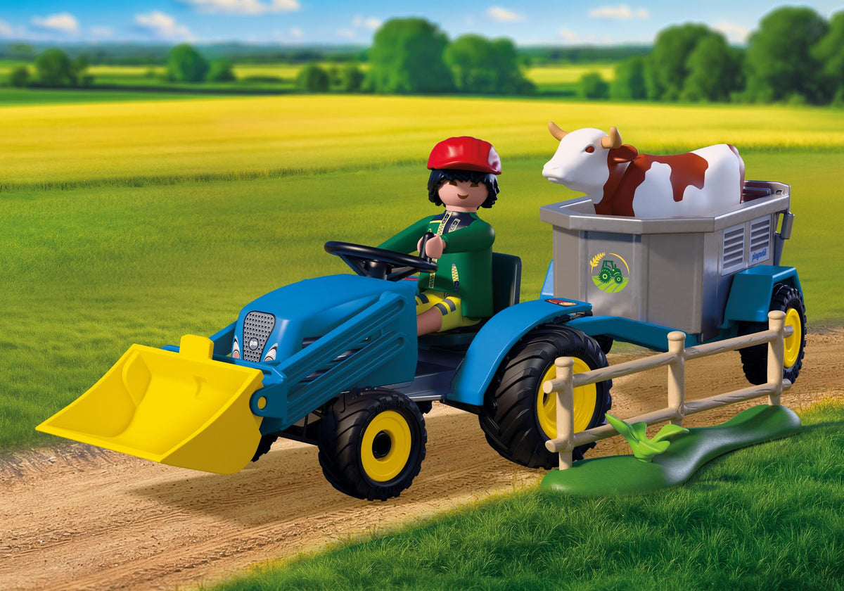 Petit tracteur bleu Playmobil Country avec pelleteuse jaune transportant une vache dans sa remorque sur un chemin de campagne.