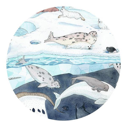 Gros plan des illustrations à l'aquarelle du puzzle Djeco montrant des phoques, un béluga et une baleine sous l'eau glacée.