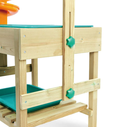Zoom sur les boutons de réglage verts en plastique installés sur le côté de la structure en bois de la table d'activité Hape, montrant le système pour ajuster la hauteur du niveau supérieur.
