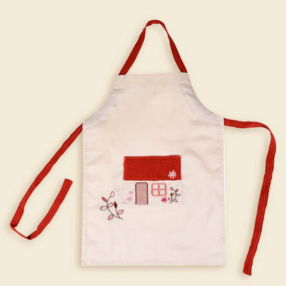 tablier en coton blanc avec attaches rouge avec une maison brodée au toit rouge sur le devant et des fleurs egmont toys